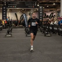Athlete controlling HYROX running pace during transition run inside exhibition hall