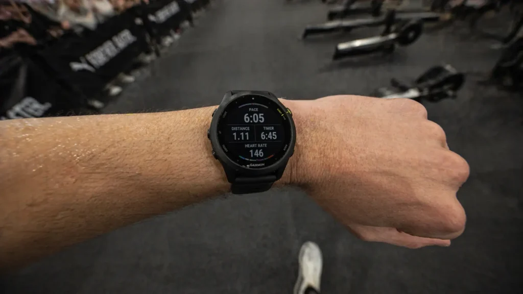Garmin Forerunner 255 displaying HYROX running pace during race inside exhibition hall