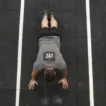 how to train burpee broad jumps for HYROX — athlete in plank position on rubber floor during station 4
