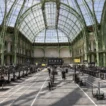 HYROX cost in France — Paris Grand Palais race venue with athletes competing across sled pull lanes under the iconic glass roof