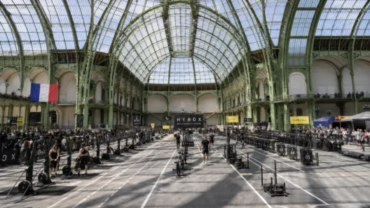 HYROX cost in France — Paris Grand Palais race venue with athletes competing across sled pull lanes under the iconic glass roof