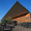 HYROX cost in Germany — Messe Karlsruhe venue exterior with German flag and athletes gathering before race day