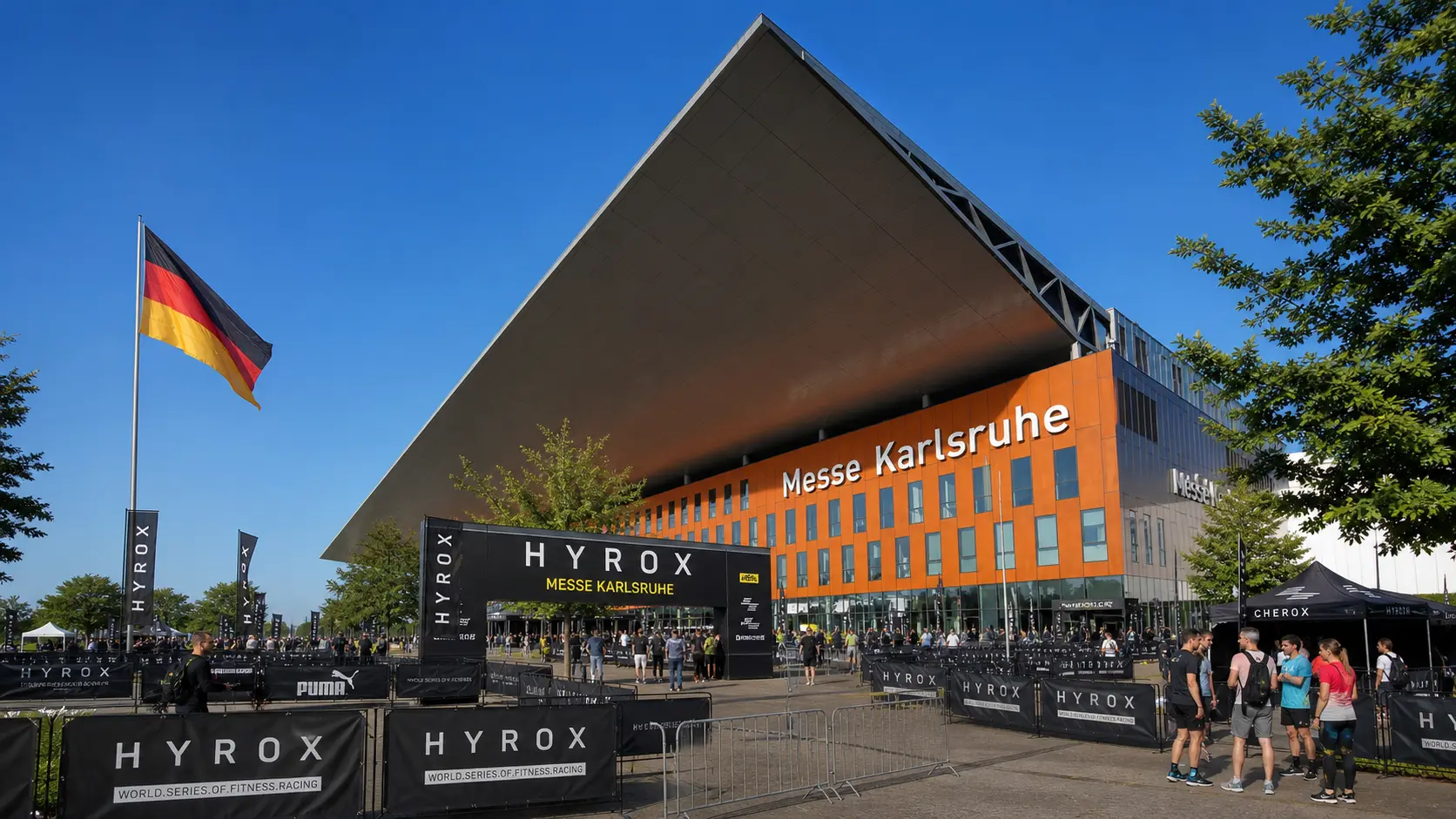 HYROX cost in Germany — Messe Karlsruhe venue exterior with German flag and athletes gathering before race day
