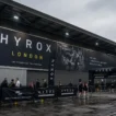 HYROX London 2026 — athletes queuing at the ExCeL London venue entrance on race day, HYROX London signage visible