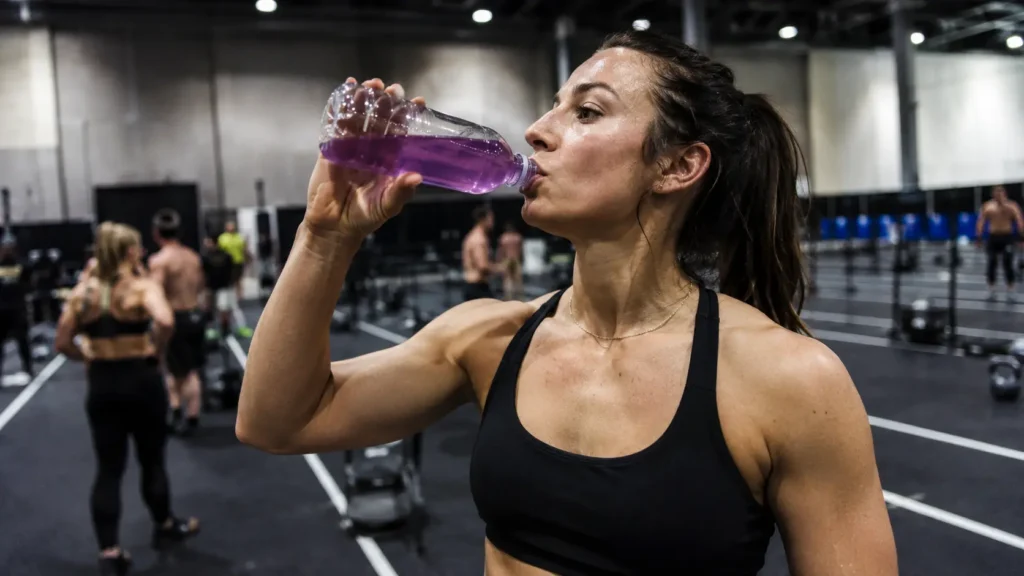 Athlete drinking an electrolyte drink after HYROX training to rehydrate