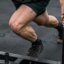 HYROX injury prevention: close-up of knee and leg position during a sled push to avoid strain