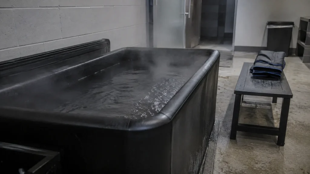 Ice bath tub and folded compression gear in a gym recovery area