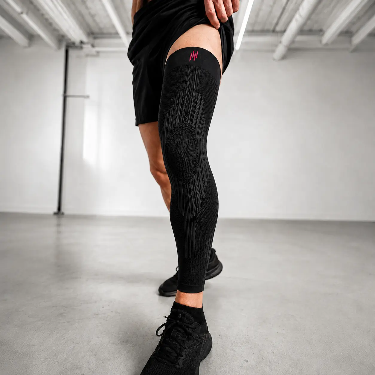 Athlete wearing HYROX compression sleeve during a sled push