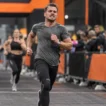 Man running toward the HYROX finish line — HYROX average finishing time for men